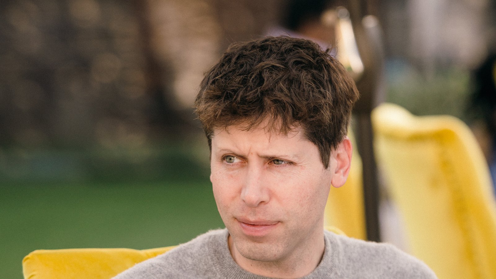 OpenAI CEO'su Sam Altman, bir etkinlikte otururken