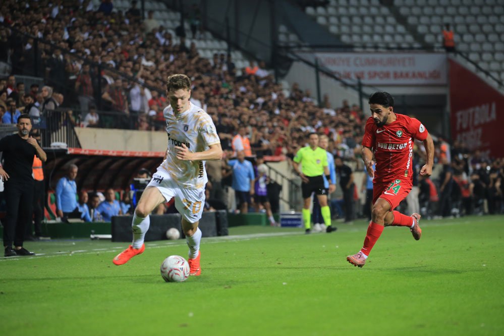 GÖVDE — Başakşehir'in 70 numaralı oyuncusu topla ilerliyor, Amedspor'un 14 numarası kovalıyor, kenarda teknik heyet; 999