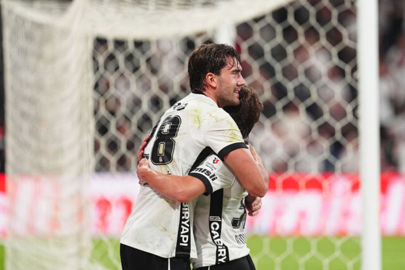 Beşiktaşlı oyuncu siyah-beyaz deplasman forması ile tribün önünde kutlama yapıyor, gece maçı a