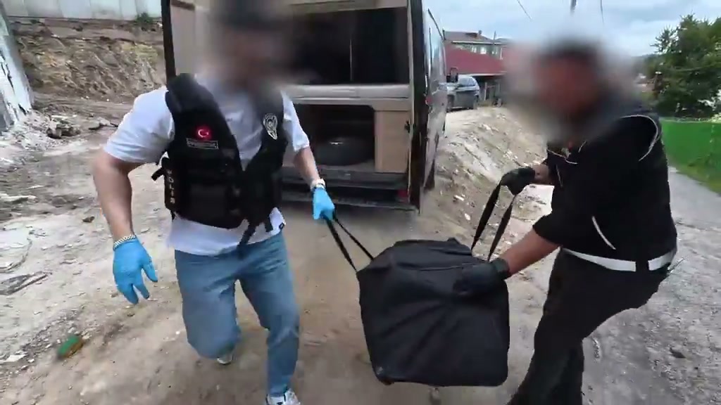 Narkotik ekipleri minibüsten skunk dolu çantayı çıkarıyor