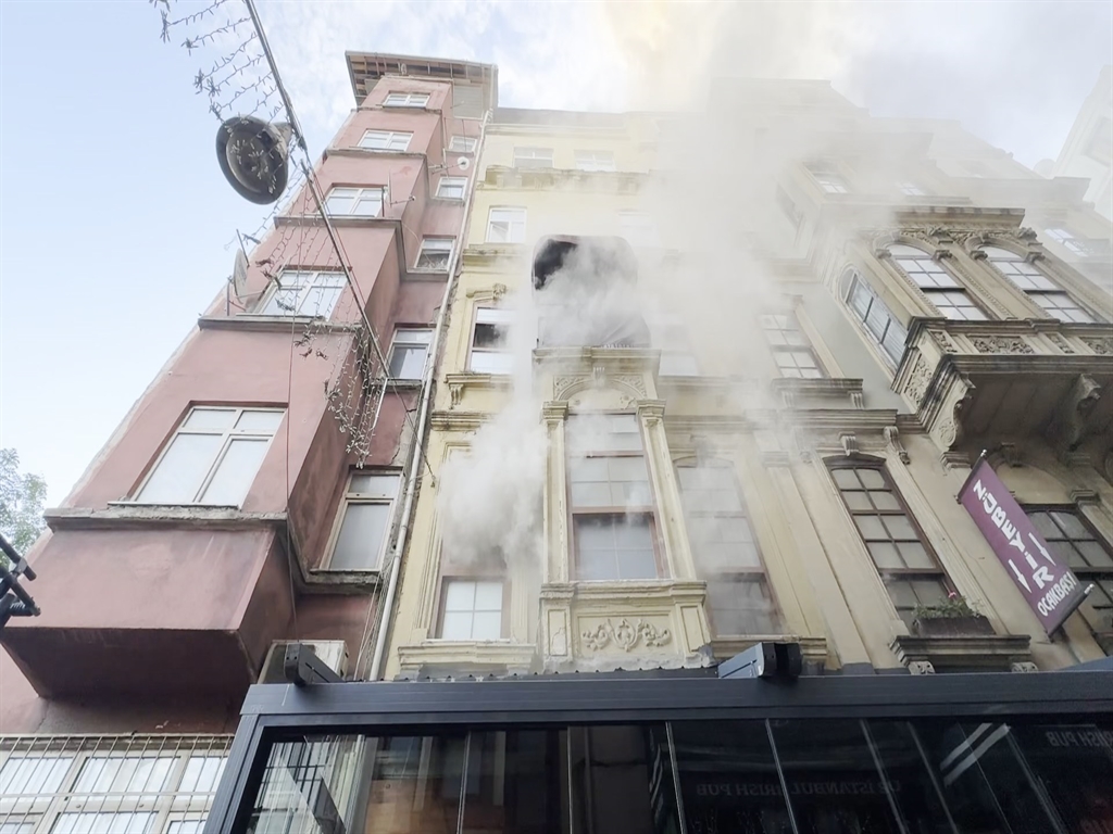 Kırılan penceresinden yoğun duman çıkan bina cephesi, yangının büyüklüğünü gösteriyor