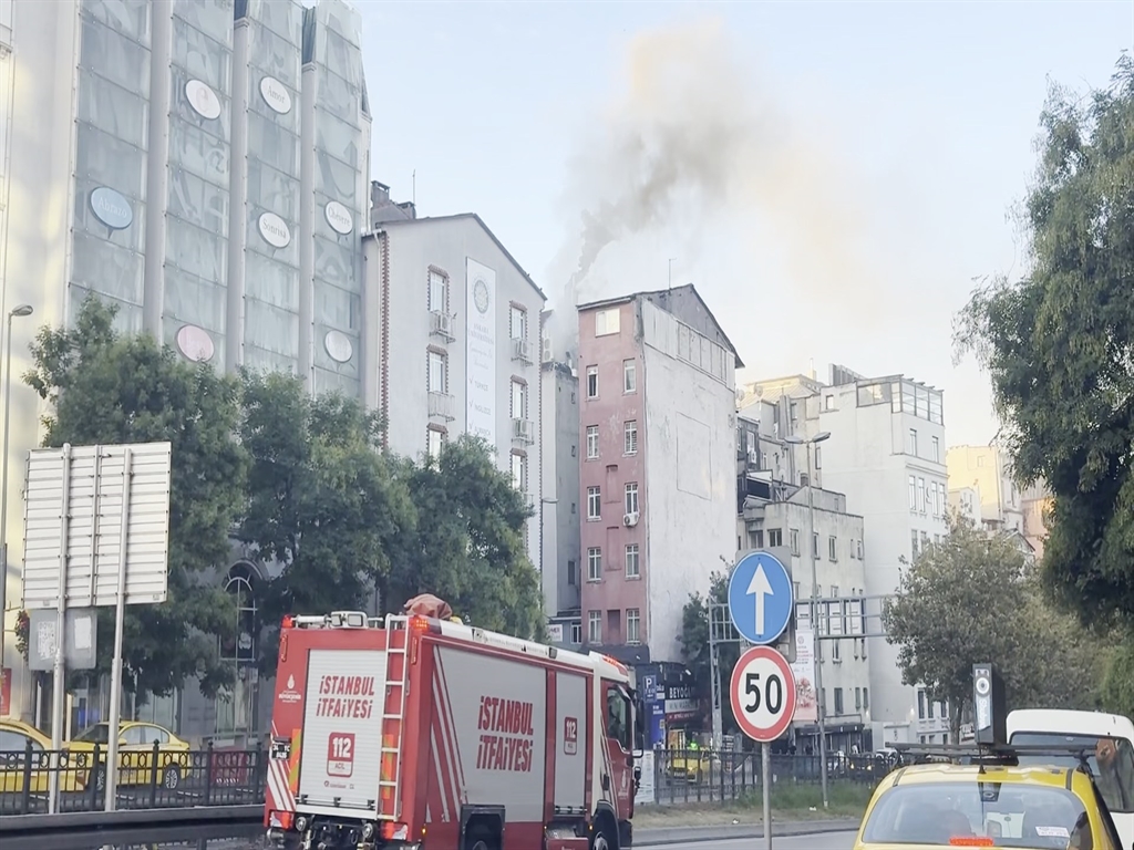 Olay yerine sevk edilen İstanbul İtfaiyesi aracı ve arka planda binadan yükselen duman