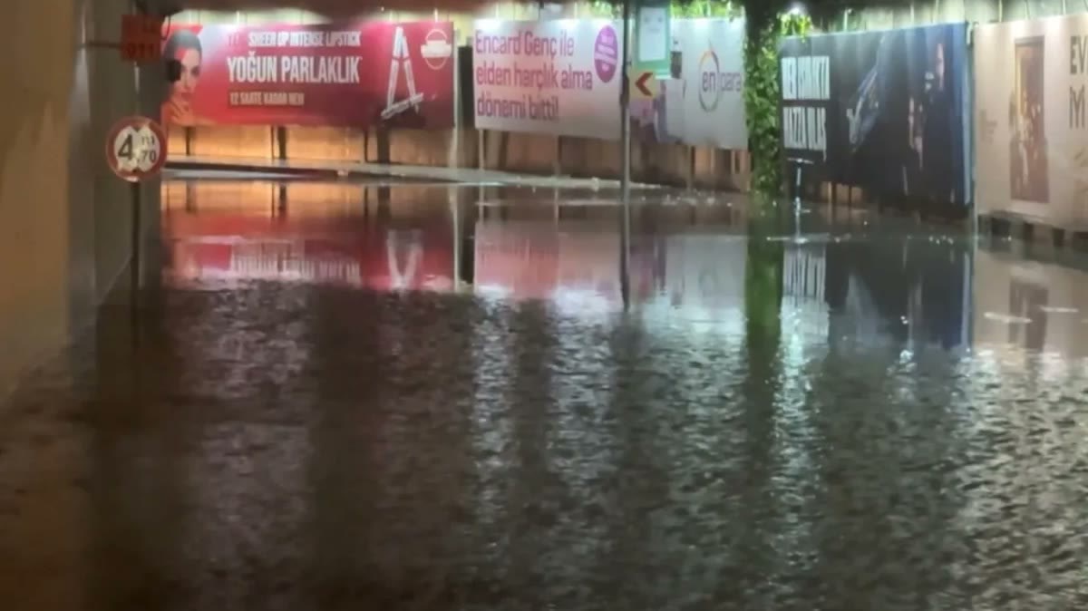 Sağanak sonrası suyla dolmuş alt geçit/yol, su yüzeyinde reklam panolarının yansıması; su baskını konusu için gövde görseli. Arka planda reklam panosu yazıları var. Kendi arşivimiz.
