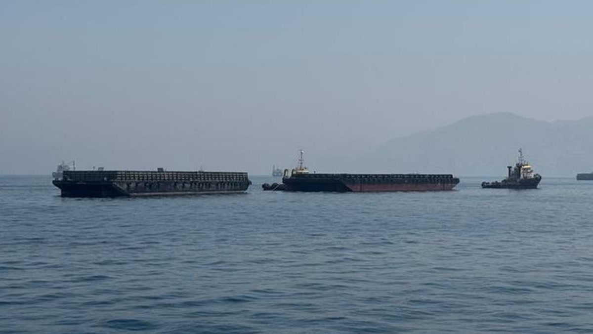 Hürmüz Boğazı'nda duran mavnalar ve römorkör, 1280x720; tanker değil, ortam fotoğrafı, gövde yedeği.
