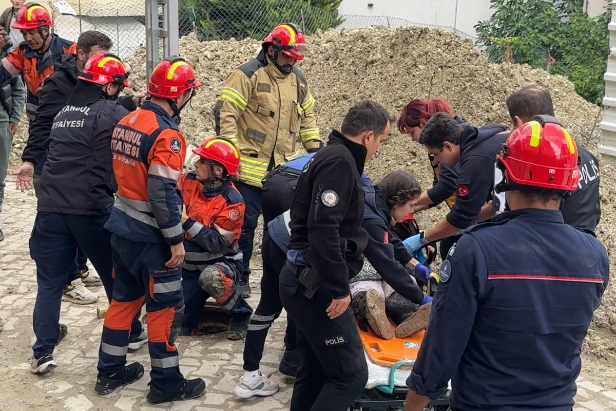 1200x800, temiz: rögardan çıkarılan yaşlı kadının turuncu sedyeye alındığı an, çevresinde İstanbul İtfaiyesi erleri, polis ve sağlık ekipleri; gövdeye ikinci foto için uygun