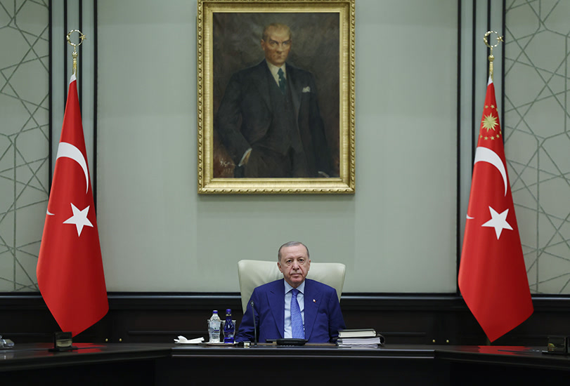 Cumhurbaşkanı Recep Tayyip Erdoğan MGK toplantısında başkan koltuğunda, iki yanında Türk bayrağı, arkada Atatürk portresi (811x550, resmî TCCB albümü)