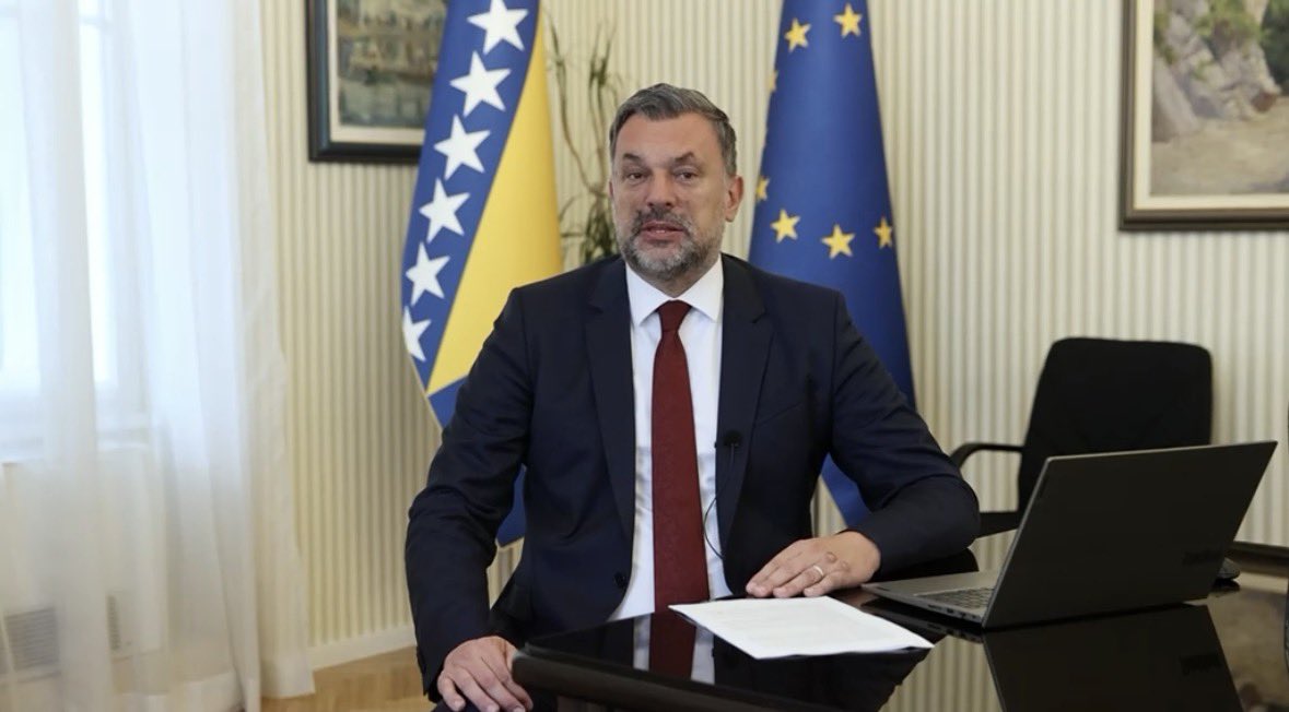 GOVDE 1: Konakovic'in 12 Eylul video mesajindan kare; masada, arkasinda Bosna Hersek ve AB bayraklari. 1179x652, Bosna H