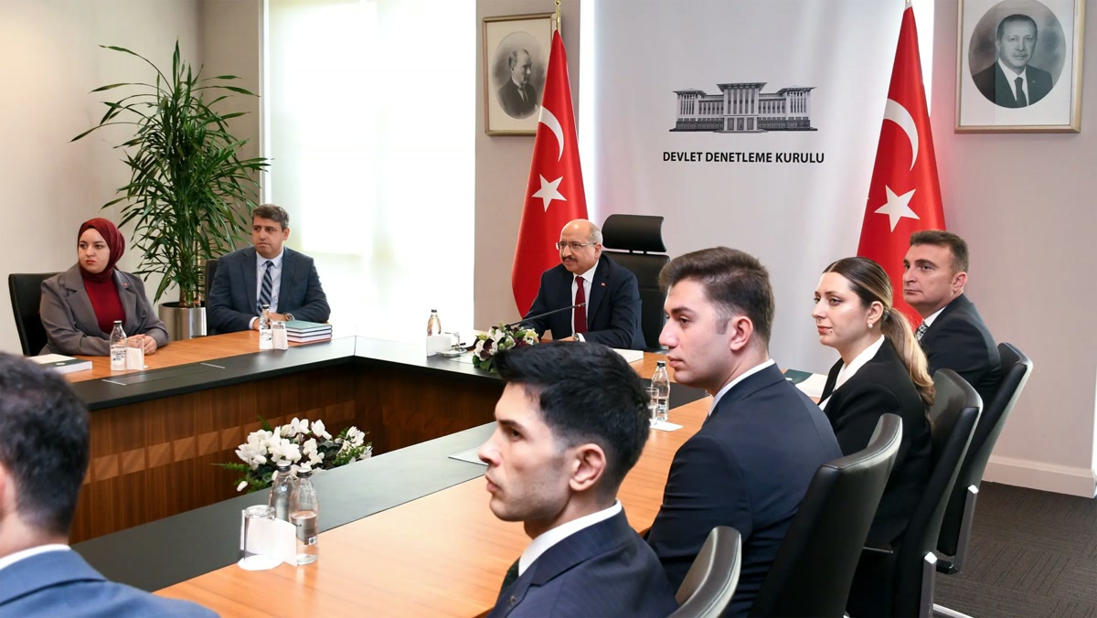 Devlet Denetleme Kurulu toplantı salonu: arka planda 'DEVLET DENETLEME KURULU' panosu ve iki Türk bayrağı, masa başında Salih Tanrıkulu, çevresinde kurul mensupları. 2560x1440, temiz, filigransız, yazılı kart/kolaj değil. En iyi kapak adayı.