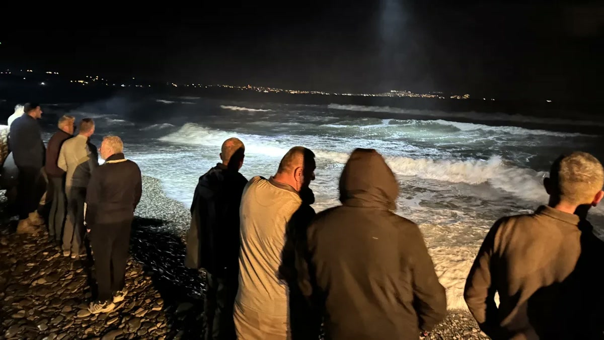 1280x720 webp, temiz: Gece projektör ışığında köpüren dalgalara bakan kalabalık, Sinop kıyısı, arka planda şehir ışıkları. Gövde fotoğrafı için uygun.