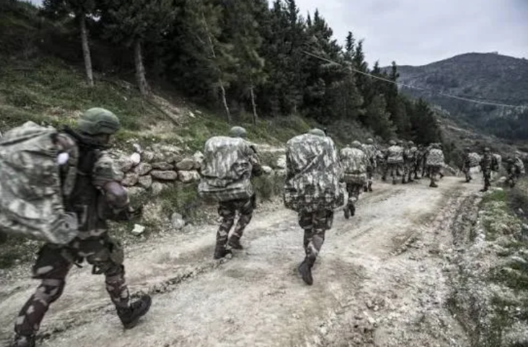 GÖVDE — Komando timinin dağlık/ormanlık arazide sırt çantalarıyla yürüyüşü, gerçek fotoğraf. Görsel olarak dogrulandi.