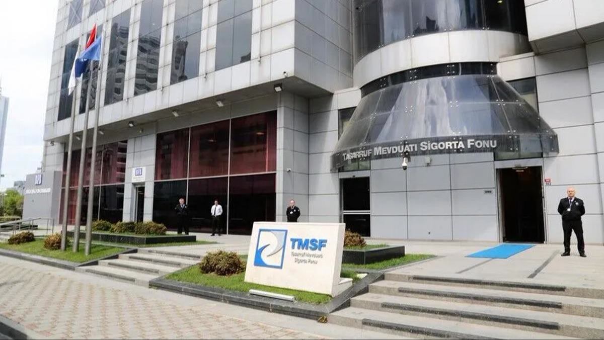 Tasarruf Mevduatı Sigorta Fonu (TMSF) genel merkez binası, girişteki TMSF tabelası ve bayraklar, güvenlik görevlileri; gün ışığında net, filigransız yatay kare (1200x675).