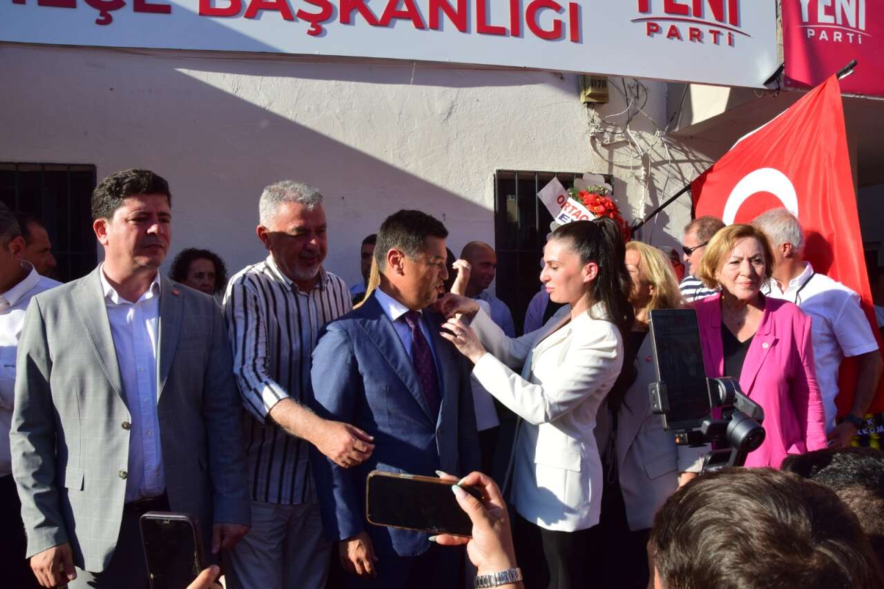 GÖVDE 1 - Rozet anının geniş karesi, Ünlü ve Özcan kalabalığın ortasında, arkada bayrak. 1280x854, temiz (Muğla Gazetesi